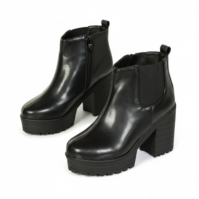 Black platform ankle boots with side zippers and elastic side panels, shown on a model's feet with dimension arrows indicating a 9.5 cm heel height.