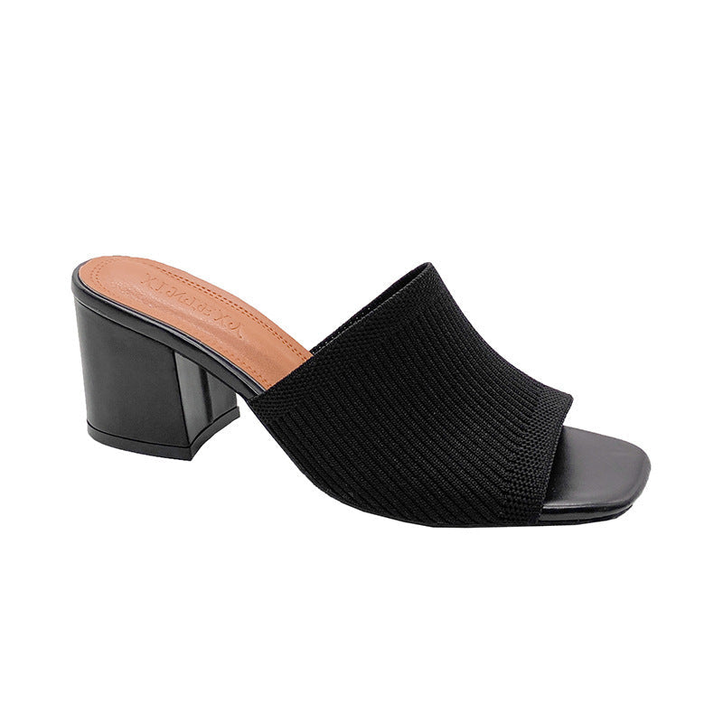 Black open-toe mule shoe on a white background